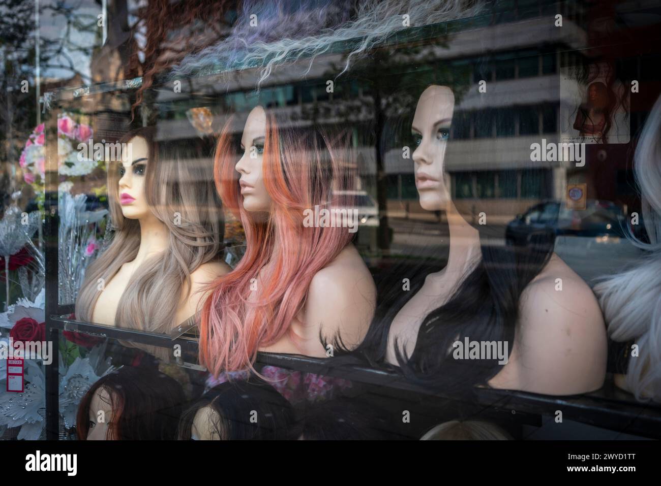 Drei Perücke Schaufensterpuppen in einem Fenster für einen Laden, der Haarverlängerungen entlang der Commercial Street in Southampton, Hampshire, England, Großbritannien verkauft Stockfoto