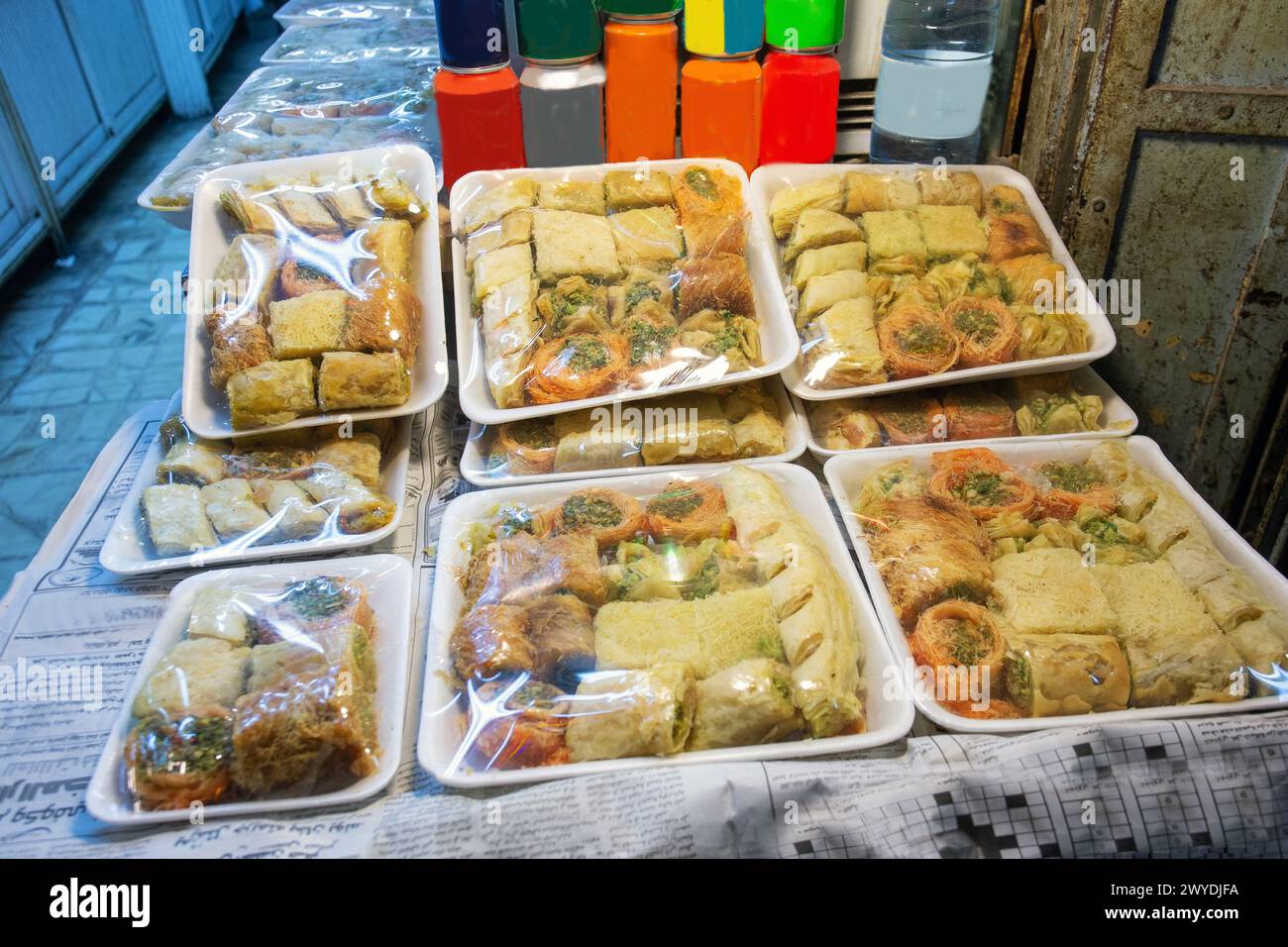 Baklava und andere Süßigkeiten in der Altstadt von Jerusalem. Verkäufer im Fernabsatz. Abend im muslimischen Viertel in der Festung. Süße kohlensäurehaltige Getränke in Metalldose Stockfoto