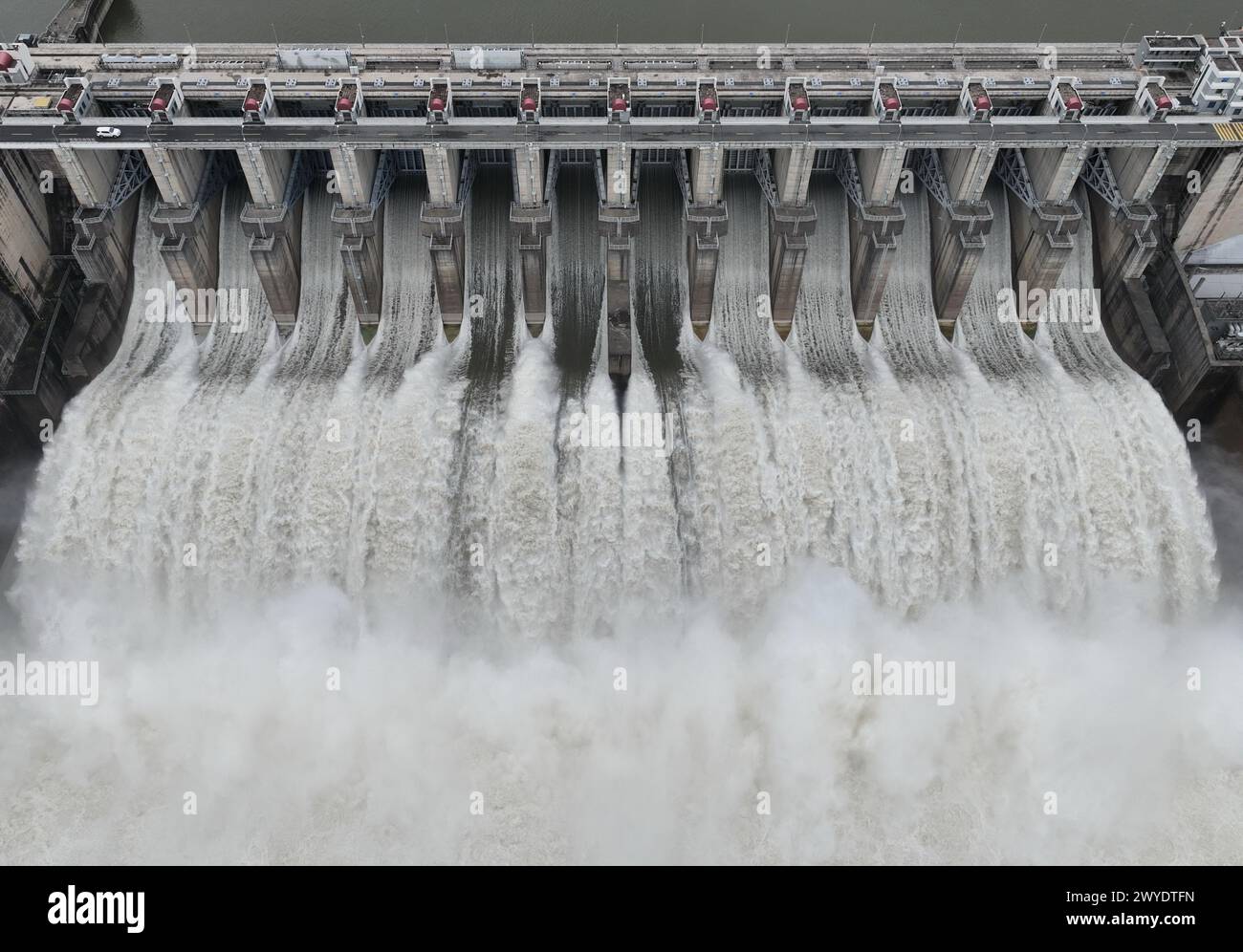 Peking, China. April 2024. Eine Luftdrohne, die am 5. April 2024 aufgenommen wurde, zeigt, wie das Wasserkraftwerk Shuikou seine Schleusen für die Wasserableitung öffnet, weil die jüngsten Regenfälle am Oberlauf des Minjiang-Flusses in der südöstlichen Provinz Fujian stattgefunden haben. Quelle: Lin Shanchuan/Xinhua/Alamy Live News Stockfoto