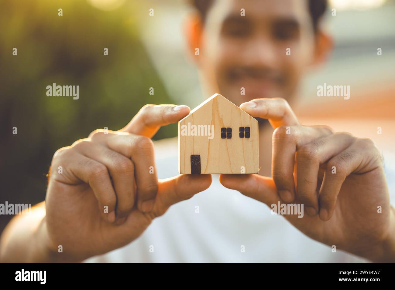 Leute Hand halten Miniatur Holz Haus Modell für Bank Wohnung Hypotheken Immobilien Miete Haus Familie Konzept Stockfoto