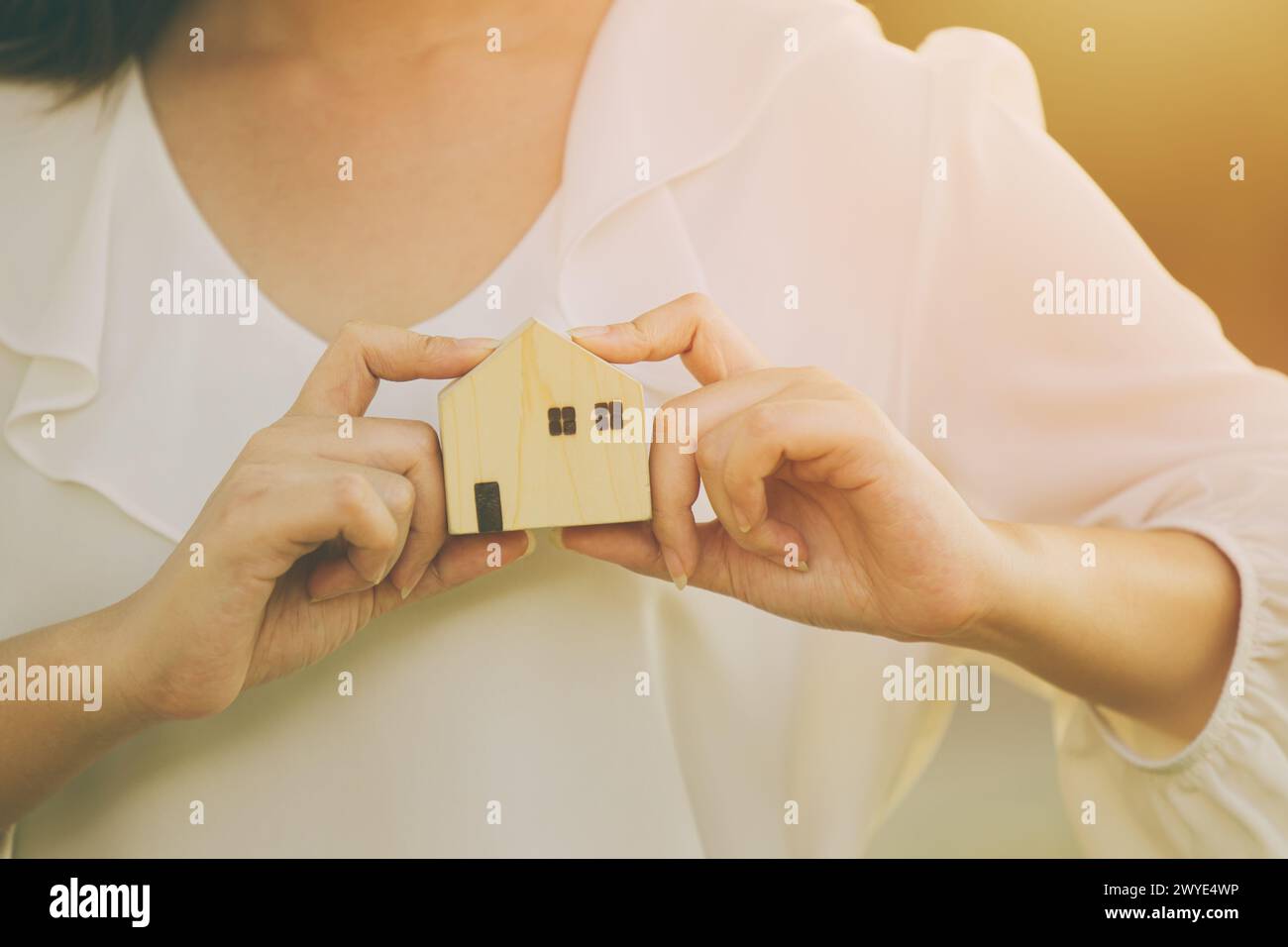 Leute Hand halten Miniatur Holz Haus Modell für Bank Wohnung Hypotheken Immobilien Miete Haus Familie Konzept Stockfoto