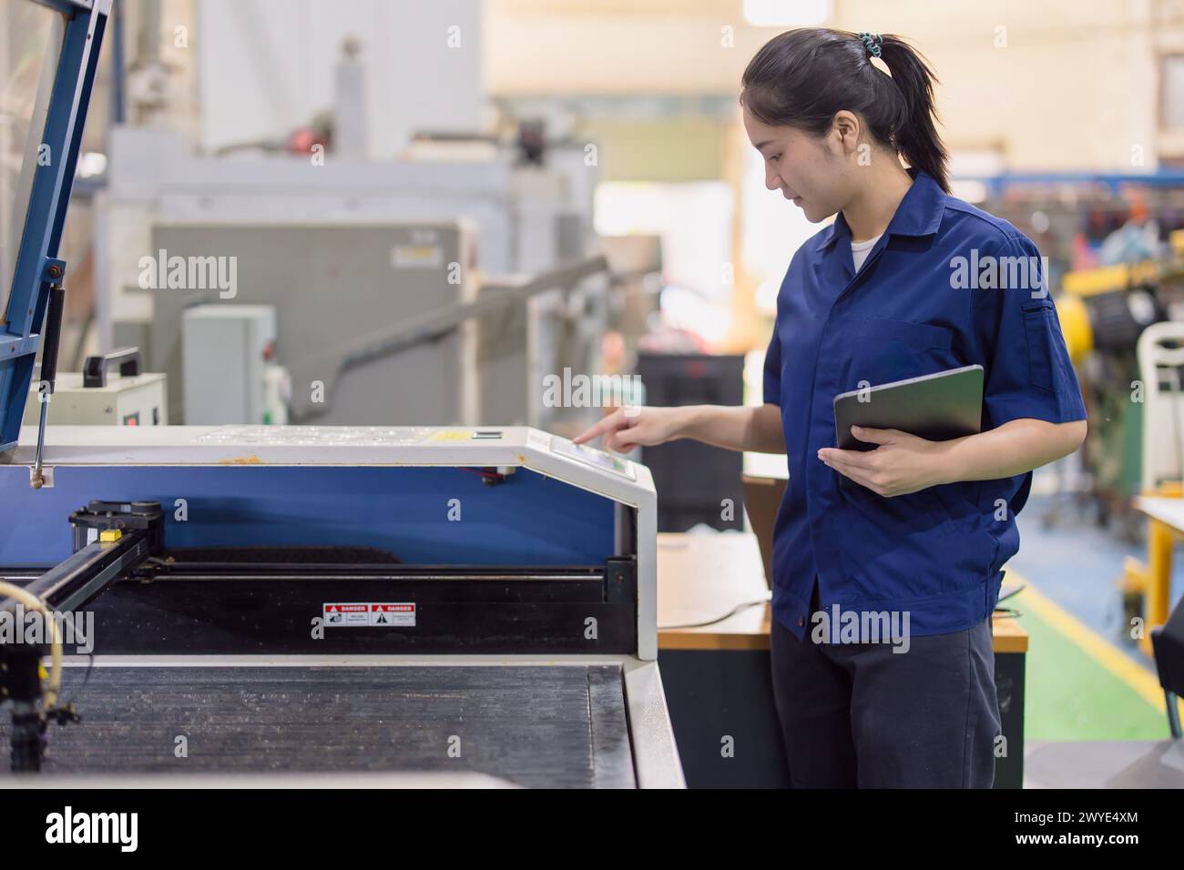 Asiatische Arbeiterinnen arbeiten in der Schwerindustrie mit CNC-Drehmaschine Fräsen Metallmaschine in Stahlproduktfabrik Stockfoto