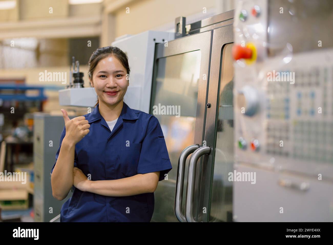 Porträt asiatische Arbeiterin der Schwerindustrie. Die junge Ingenieurin, die glücklich ist, Daumen hoch. Stockfoto