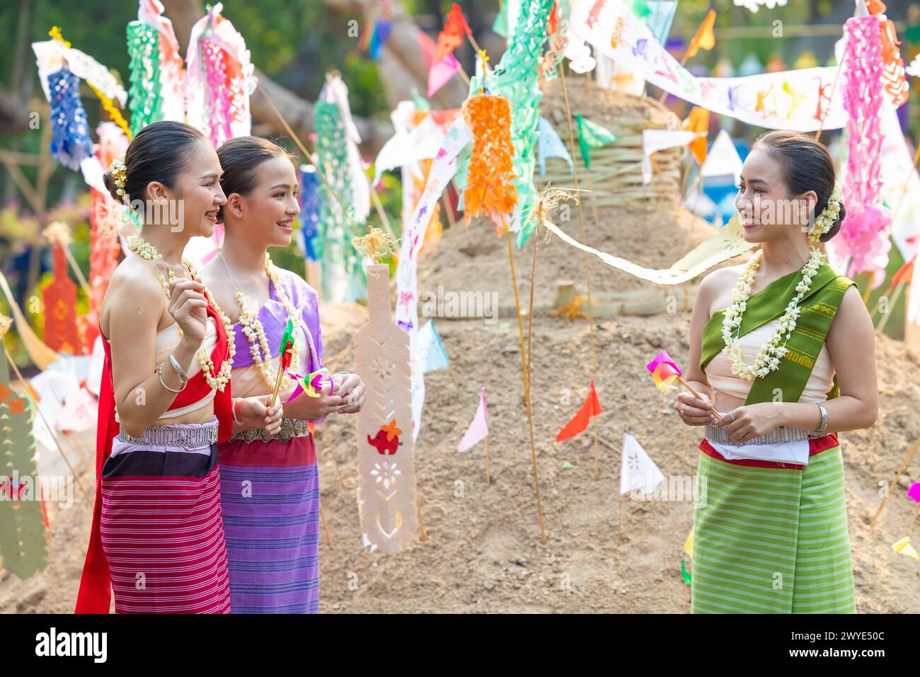 Songkran Festival. Nordthailändische Menschen in traditioneller Kleidung tragen Sand in den Tempel, um Sandpagode und Dekoration mit farbenfrohen PA zu bauen Stockfoto