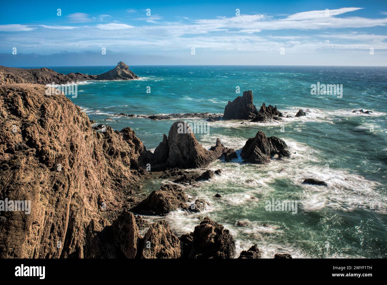 Zerklüftete Klippen erheben sich über dem schäumenden Wasser des Arrecife de las Sirenas in Spanien. Stockfoto