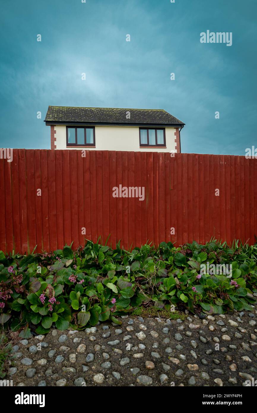 Haus hinter rotem Zaun Stockfoto