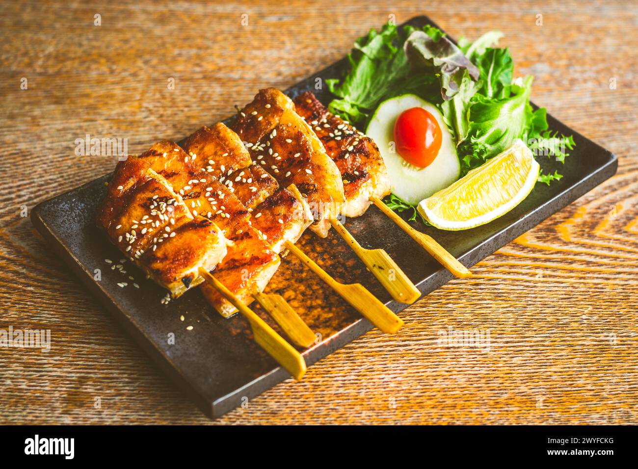 Gegrillter Lachsbauchspieß mit Teriyaki-Sauce und Sesamsamen mit Salat auf der Seite Stockfoto
