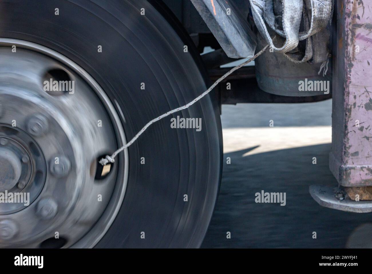 Detail eines sich drehenden Rades eines Lastwagens, der auf der Autobahn fährt. Stockfoto