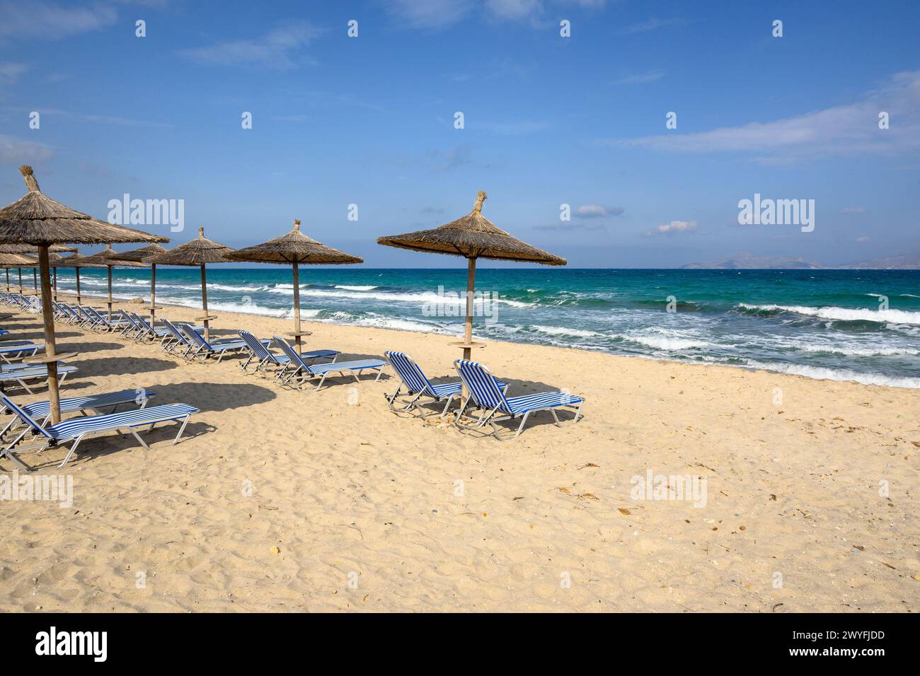 Sonnenliegen mit Sonnenschirm am Sandstrand von Marmari. Die griechische Insel Kos Stockfoto