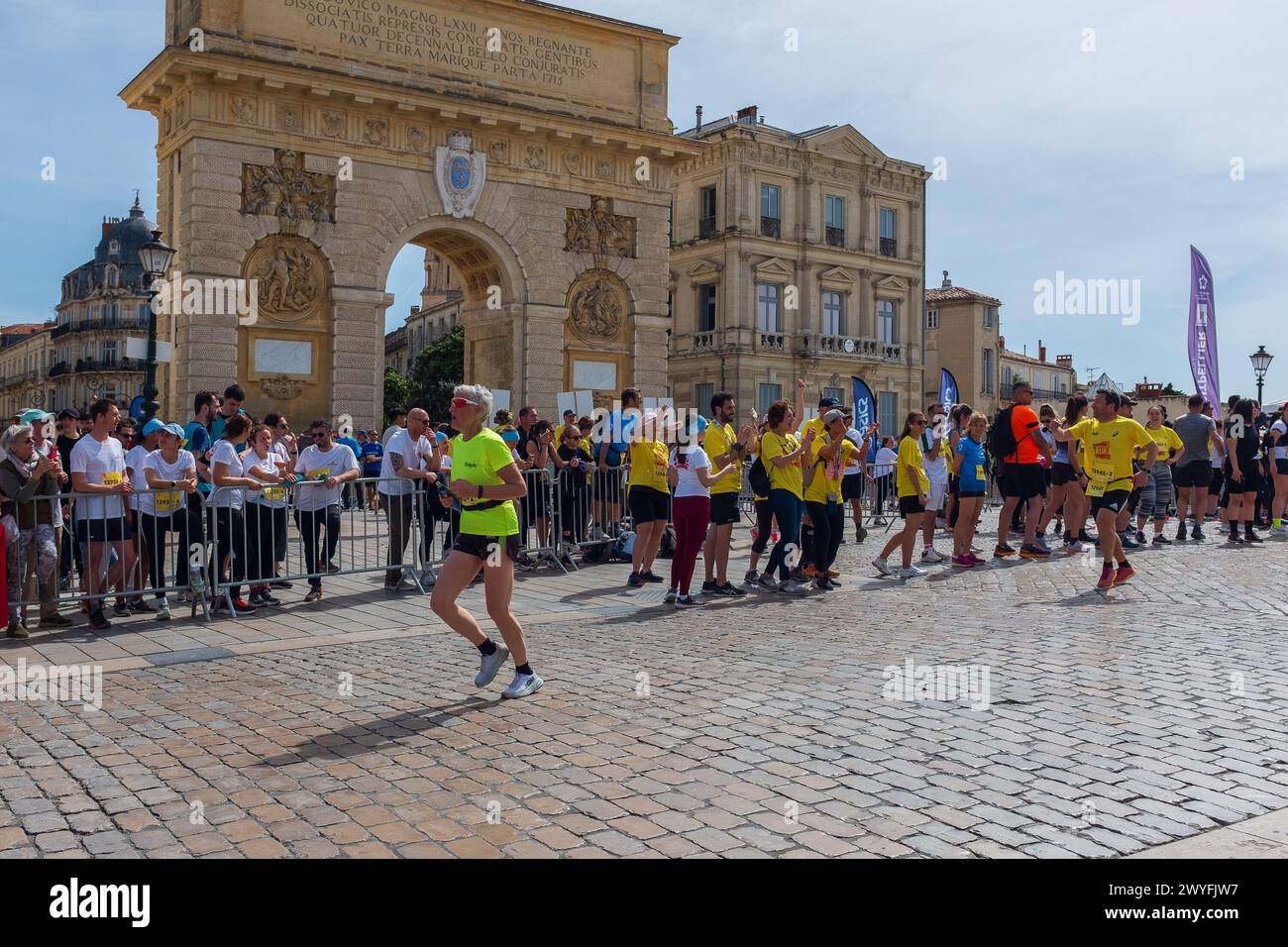 Montpellier, Frankreich. April 2024. Ekiden-Staffelteilnehmer laufen am Triumphbogen vorbei, und die Öffentlichkeit jubelte sie an. Credit ReportageMPL/Alamy Live News Stockfoto