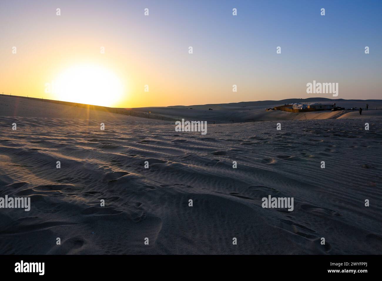 Katar Wüstenlandschaft Sanddünen am Sonnenuntergangshimmel in der Nähe des Meeresstrandes. Stockfoto