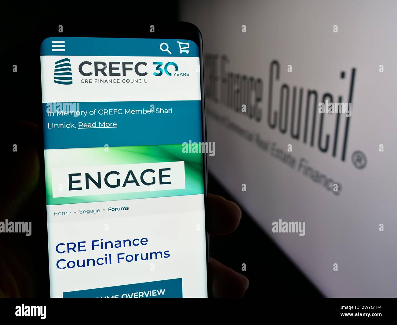 Person, die ein Mobiltelefon hält, mit Webseite des Wirtschaftsverbandes CRE Finance Council (CREFC) vor dem Logo. Konzentrieren Sie sich auf die Mitte des Telefondisplays. Stockfoto