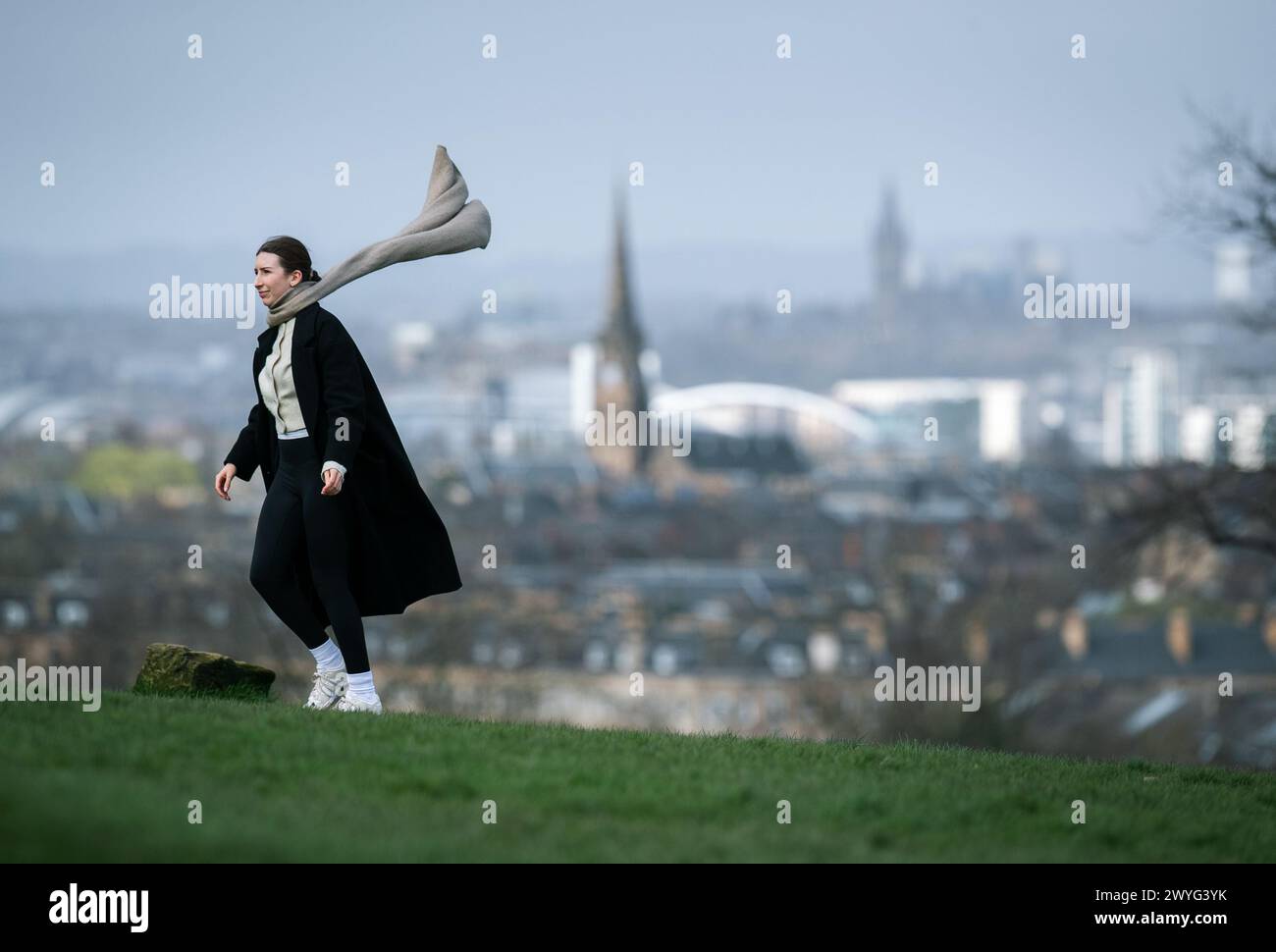 Frau, die im Wind läuft, im Park in Glasgow Stockfoto