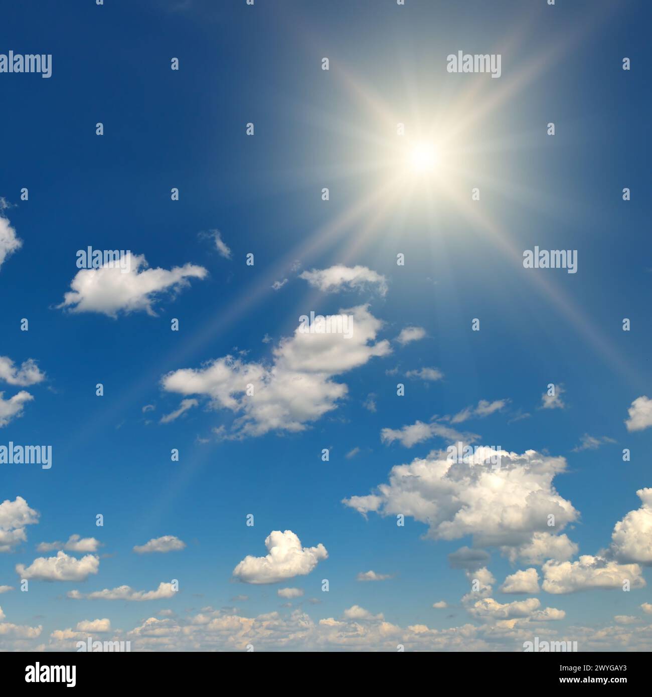 Helle Sonne am wunderschönen blauen Himmel mit weißen, flauschigen Wolken. Stockfoto