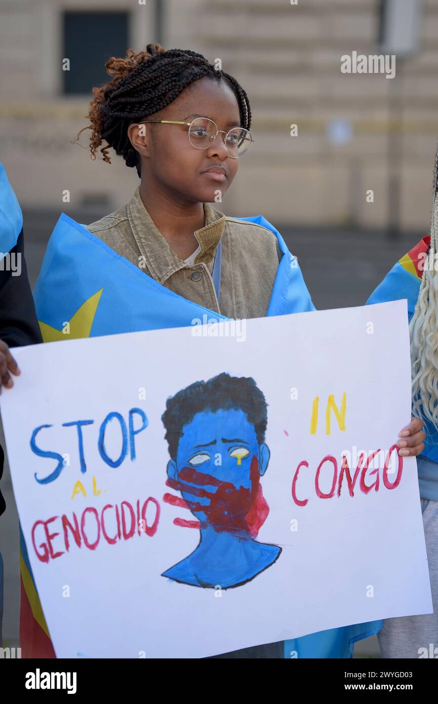 Rom, Italien. April 2024. Ein Mädchen hält während der Demonstration ein Schild mit der Zeichnung einer blutigen Hand, die den Mund eines Mannes bedeckt, und die Worte "stoppt den Völkermord im Kongo", um Solidarität mit dem kongolesischen Volk auszudrücken. die Forderung nach einer "Beendigung des anhaltenden Völkermords" und einer Beendigung der Ausbeutung des afrikanischen Kontinents, die von einigen Verbänden der afrikanischen Gemeinschaften Europas zusammen mit dem Kommunistischen Netzwerk und der Bewegung Hands Off from Africa in Rom organisiert werden. Den Organisatoren zufolge haben die 30 Jahre bewaffneter Konflikte, die von der westlichen Kriegsindustrie finanziert wurden, verursacht Stockfoto