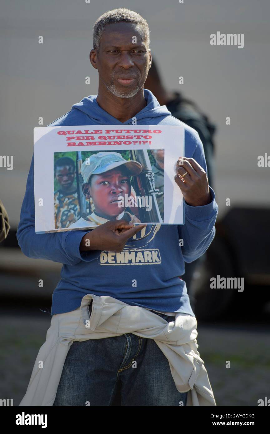 6. April 2024, Rom, Italien: Ein Mann zeigt ein Foto eines Kindersoldaten mit der Aufschrift „What Future for this Child?!?“ Während der Demonstration zum Ausdruck der Solidarität mit dem kongolesischen Volk, die Forderung nach einem "Stopp des anhaltenden Völkermords" und einem Ende der Ausbeutung des afrikanischen Kontinents, die von einigen Verbänden der afrikanischen Gemeinschaften Europas zusammen mit dem Kommunistischen Netzwerk und der Bewegung Hands Off from Africa in Rom organisiert werden. die 30 Jahre bewaffneter Konflikte, die von der westlichen Kriegsindustrie finanziert wurden, haben den Tod von 15 Millionen Zivilisten und 7 Millionen d verursacht Stockfoto