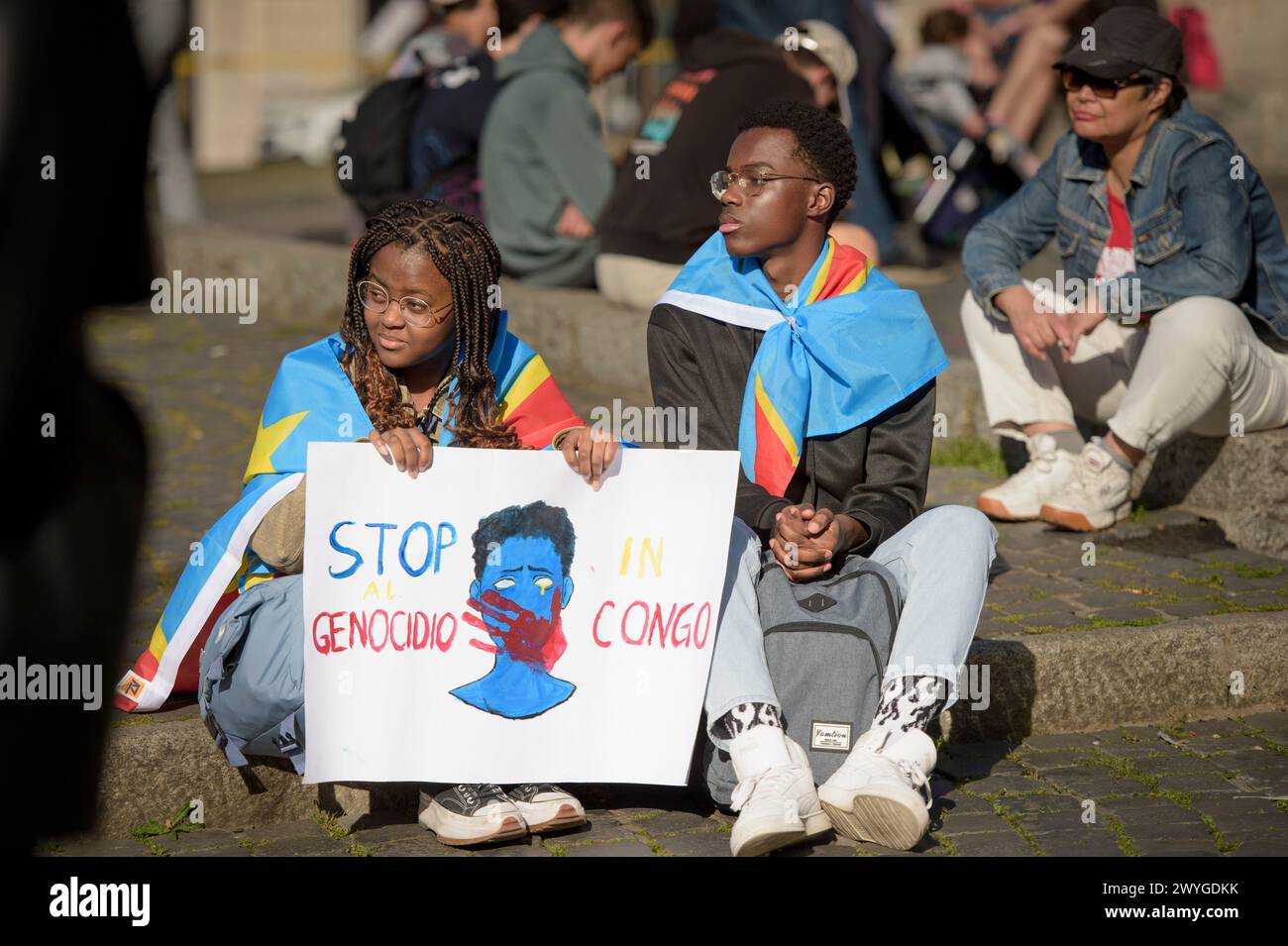 6. April 2024, Rom, Italien: Ein Junge und ein Mädchen halten während der Demonstration, um Solidarität mit dem kongolesischen Volk zum Ausdruck zu bringen, ein Schild mit einer Zeichnung einer blutigen Hand, die den Mund eines Mannes bedeckt, und die Worte "stoppt den Völkermord im Kongo". die Forderung nach einer "Beendigung des anhaltenden Völkermords" und einer Beendigung der Ausbeutung des afrikanischen Kontinents, die von einigen Verbänden der afrikanischen Gemeinschaften Europas zusammen mit dem Kommunistischen Netzwerk und der Bewegung Hands Off from Africa in Rom organisiert werden. Nach Angaben der Organisatoren haben sich die 30 Jahre bewaffneter Konflikte, die von der westlichen Kriegsindustrie finanziert wurden, geändert Stockfoto