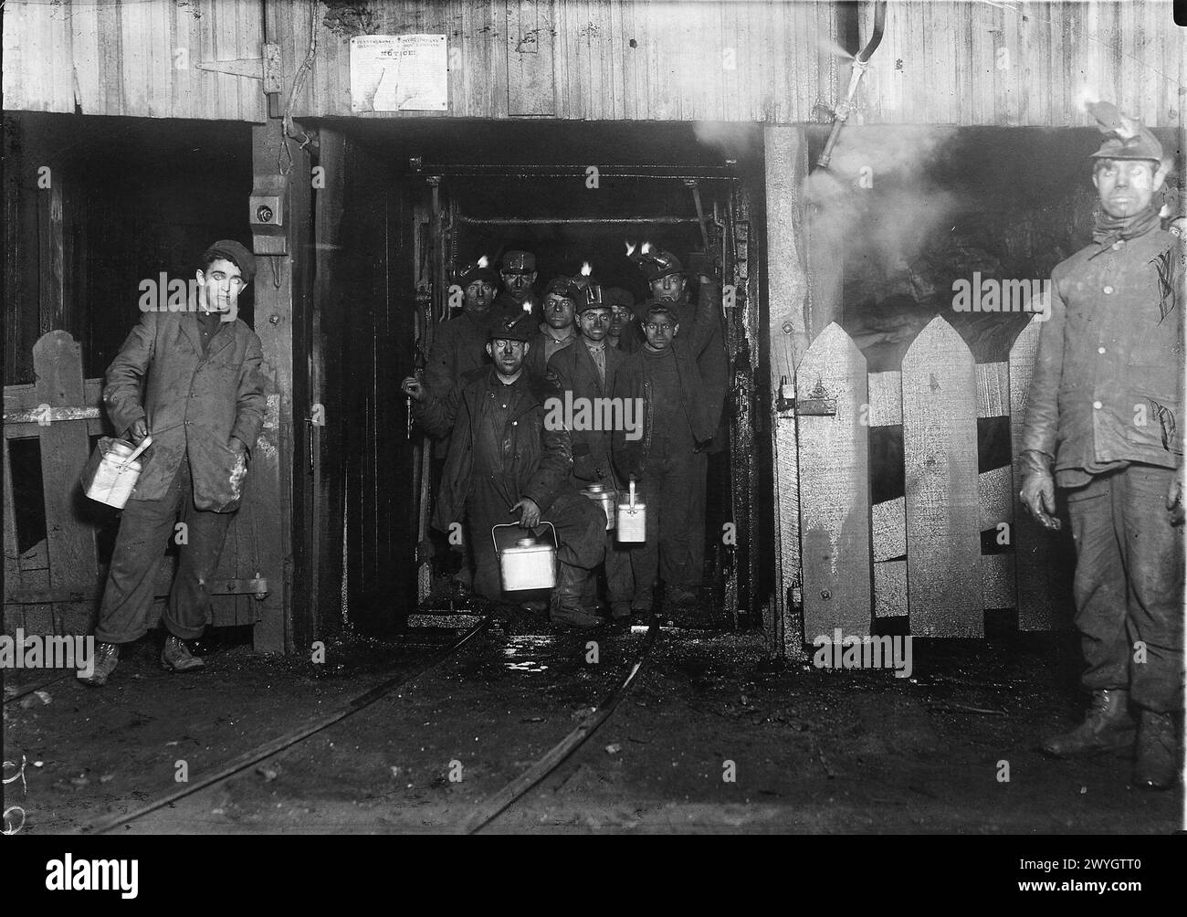 Tagesschluss in meinem. Ich warte darauf, dass der Käfig hochgeht. Der Käfig ist auf zwei Seiten vollständig offen und auf den anderen beiden nicht besonders gut geschützt und ist normalerweise so überfüllt. Der kleine Junge vorne ist Jo Puma. S. Pittston, Pennsylvania, Januar 1911 Vintage American Photography 1910s. Untergeordnetes Arbeitsprojekt. Quelle: Lewis Hines Stockfoto