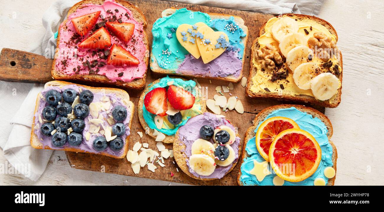 Süßes Frühstück. Bunte Toasts mit Früchten und Beeren. Kindernahrungskonzept. Draufsicht, Banner Stockfoto