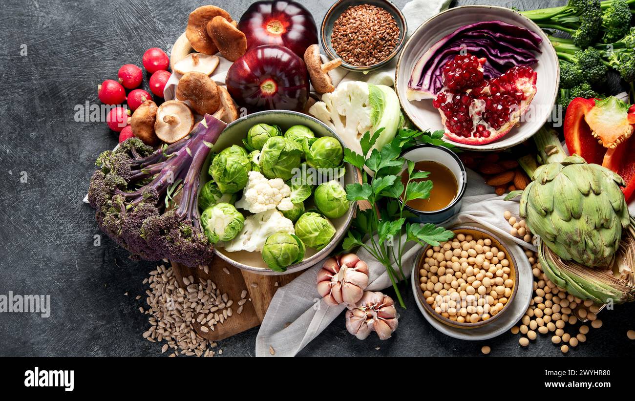 Veganes Essen. Pfeffer, Brokkoli, Kohl, Knoblauch, Pilze, Granatapfel auf dunklem Hintergrund. Draufsicht, Kopierraum Stockfoto