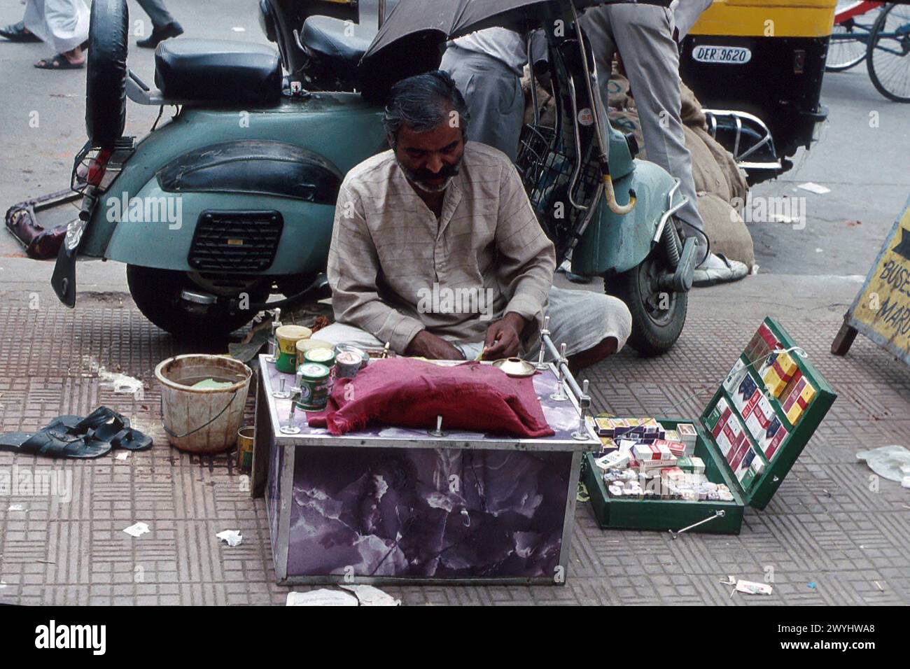 Mann repariert Gegenstände und verkauft Zigaretten auf der Straße, aufgenommen 1992, Old Delhi District, New Delhi, Indien Stockfoto