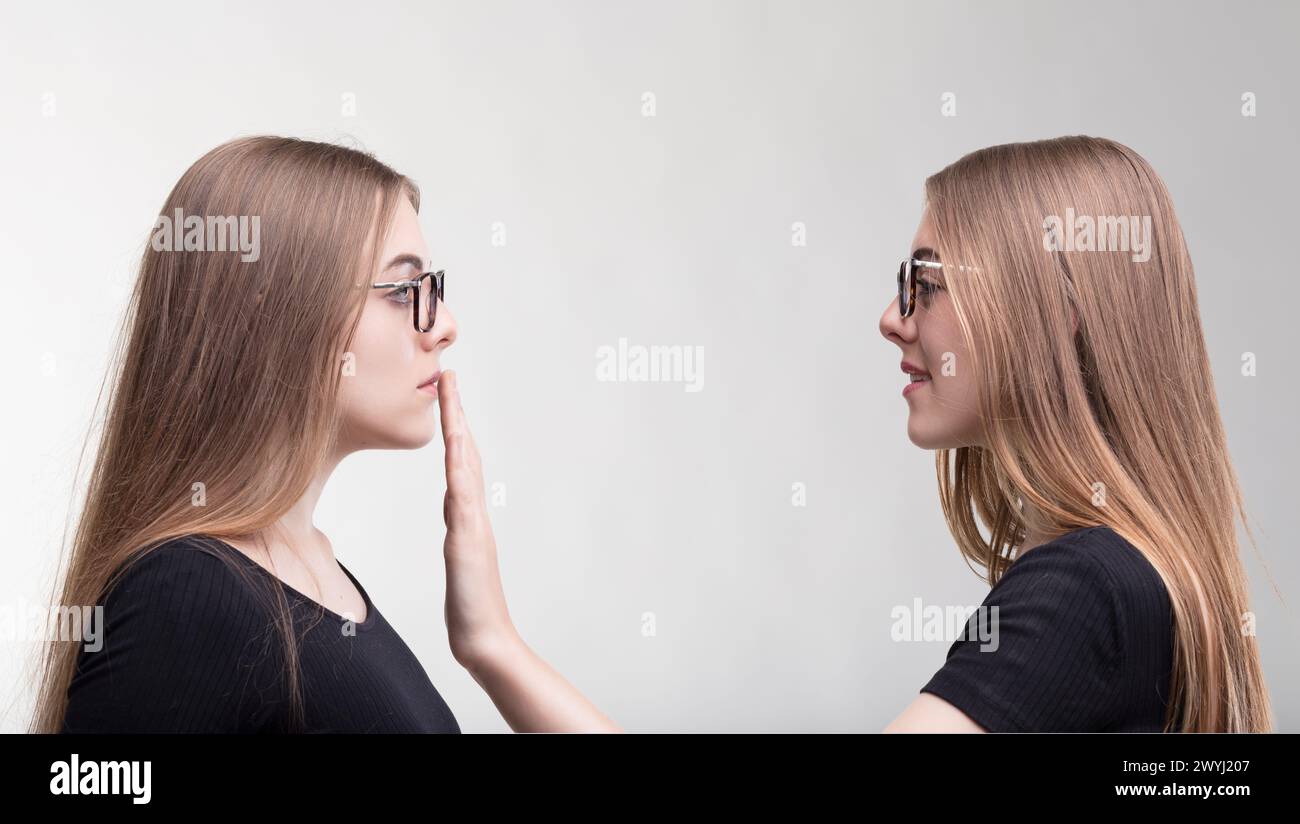 Moment der Selbstzensur, als ein Zwilling den anderen zum Schweigen bringt Stockfoto