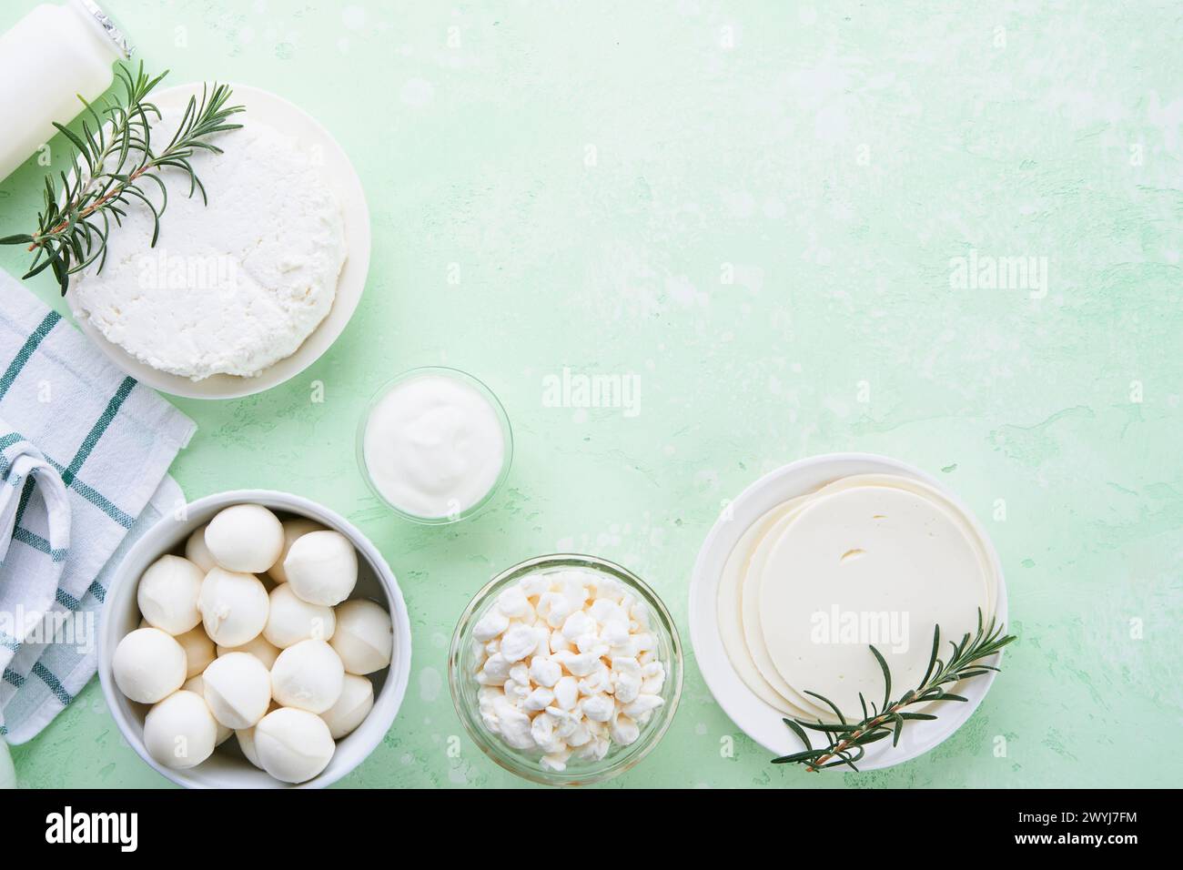 Milcherzeugnisse oder landwirtschaftliche Erzeugnisse. Frische Bio-Milchprodukte Milch, Hüttenkäse, Butter, Sahne, Joghurt, Sauerrahm und Mozzarella auf einem hellgrünen Stockfoto