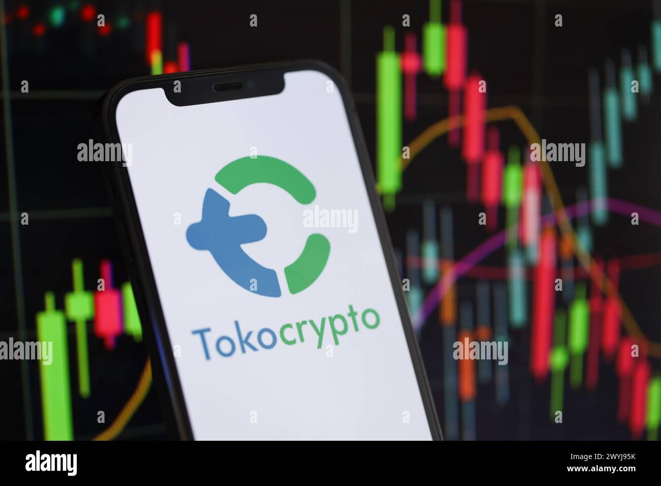 KIEW, UKRAINE - 15. MÄRZ 2024 Tokocrypto-Logo auf dem iPhone-Display und Kryptowährungswertdiagrammen. Portal für den Austausch von Kryptowährungen Stockfoto