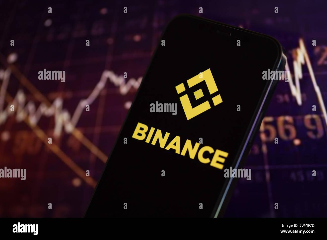 KIEW, UKRAINE - 15. MÄRZ 2024 Binance-Logo auf dem iPhone-Display und Kryptowährungswertdiagrammen. Portal für den Austausch von Kryptowährungen Stockfoto