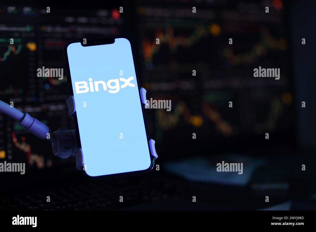KIEW, UKRAINE - 15. MÄRZ 2024 BingX-Logo auf dem iPhone-Display und Kryptowährungswertdiagrammen. Portal für den Austausch von Kryptowährungen Stockfoto