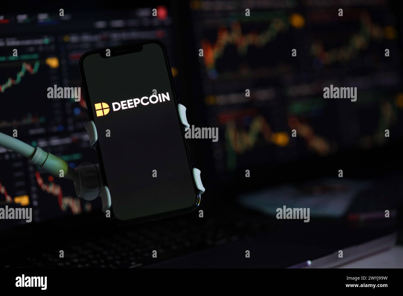 KIEW, UKRAINE - 15. MÄRZ 2024 Deepcoin-Logo auf dem iPhone-Display und Kryptowährungswertdiagrammen. Portal für den Austausch von Kryptowährungen Stockfoto