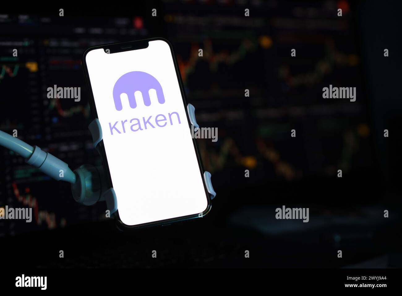 KIEW, UKRAINE - 15. MÄRZ 2024 Kraken-Logo auf iPhone-Display und Kryptowährungswertdiagramme. Portal für den Austausch von Kryptowährungen Stockfoto