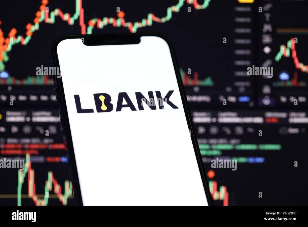 KIEW, UKRAINE - 15. MÄRZ 2024 Lbank-Logo auf iPhone-Display und Kryptowährungswertdiagramme. Portal für den Austausch von Kryptowährungen Stockfoto