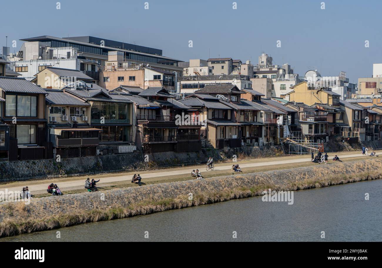 Menschen, die entlang des Kamo-Flusses in Kyoto, Japan, spazieren gehen und ausruhen Stockfoto
