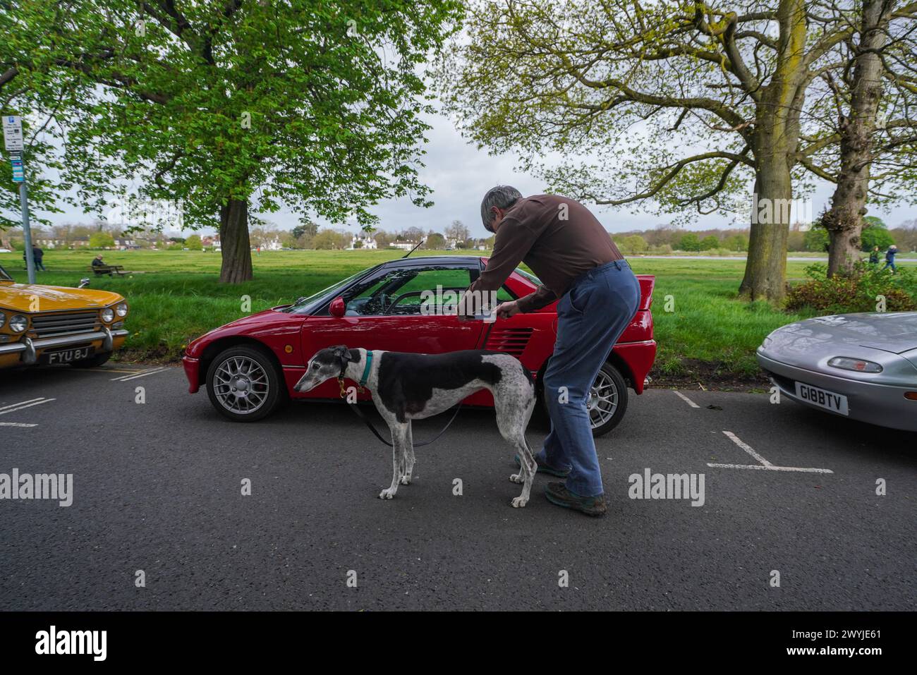 London 7 April 2024 . Ein Mann mit Hund macht ein Foto von einem AUTOZAM AZ-1 auf dem Wimbledon Common. Autobegeisterte kommen auf Wimbledon Common im Südwesten Londons zusammen, um zu zeigen, was sie fahren und die Autos aus verschiedenen Zeiträumen zu schätzen. Credit: amer ghazzal/Alamy Live News Stockfoto