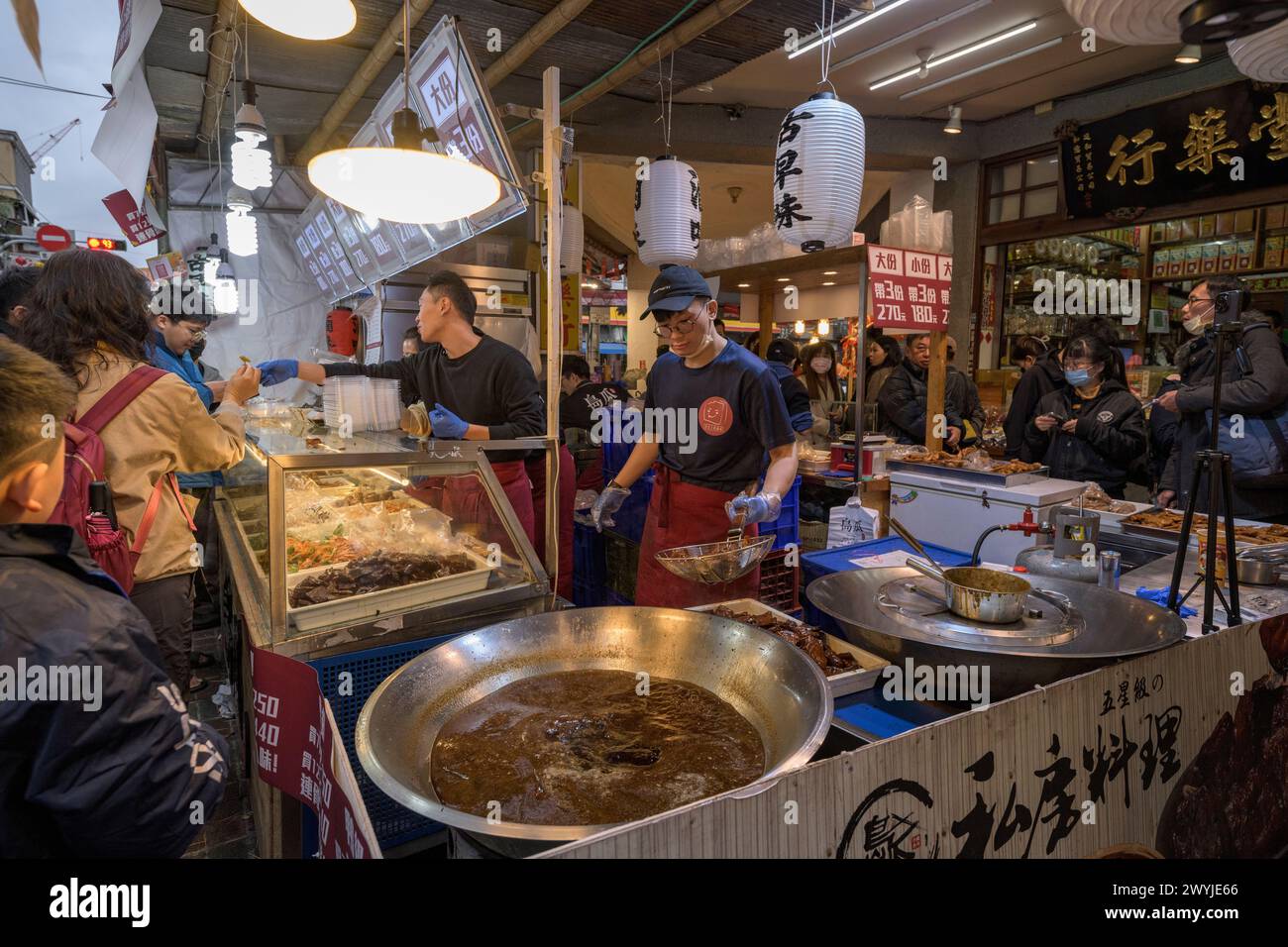Ein lebhafter und geschäftiger Street Food Markt mit verschiedenen Ständen, die lokale asiatische Küche servieren und das Wesen des täglichen Lebens einfangen Stockfoto