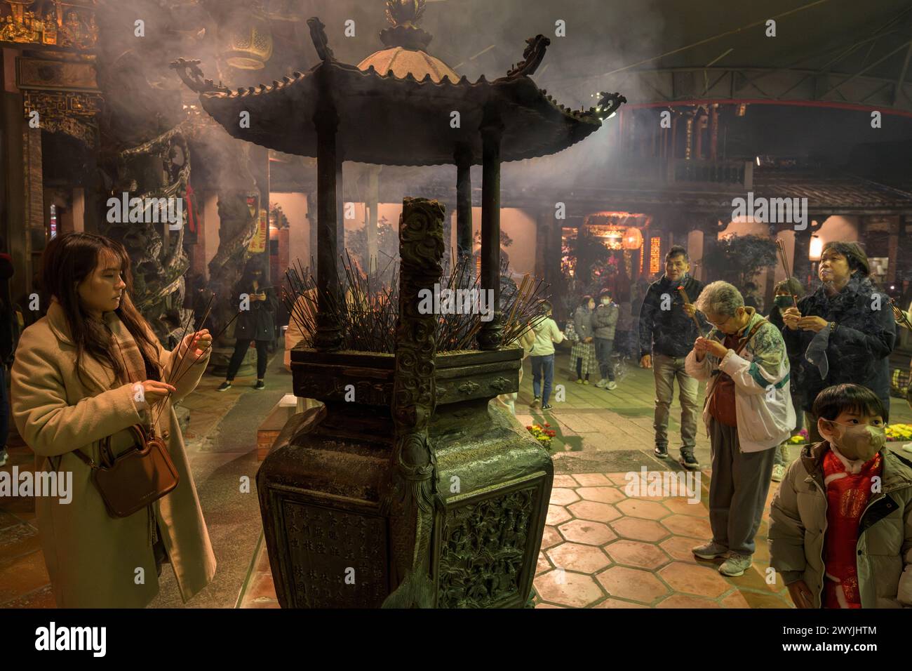 Gläubige beten im Baoan-Tempel, gefüllt mit Räucherrauch, während einer chinesischen Neujahrszeremonie Stockfoto