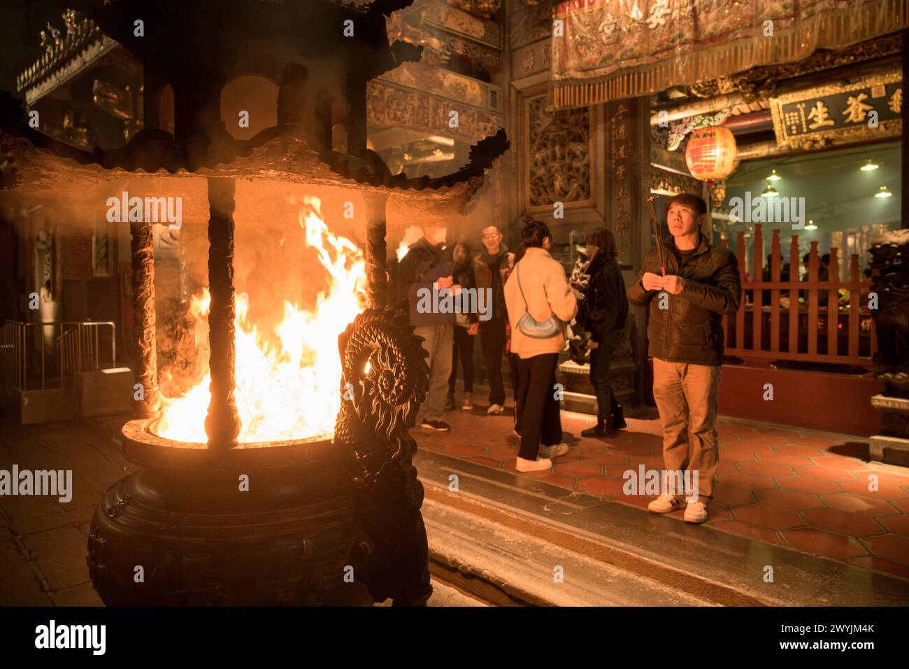 Gläubige beten im Baoan-Tempel, gefüllt mit Räucherrauch, während einer chinesischen Neujahrszeremonie Stockfoto