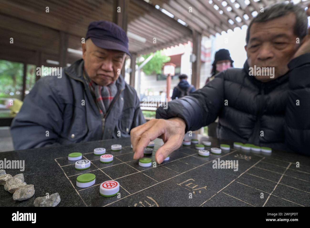 Senior-Männer konzentrierten sich stark auf ein strategisches Brettspiel Stockfoto