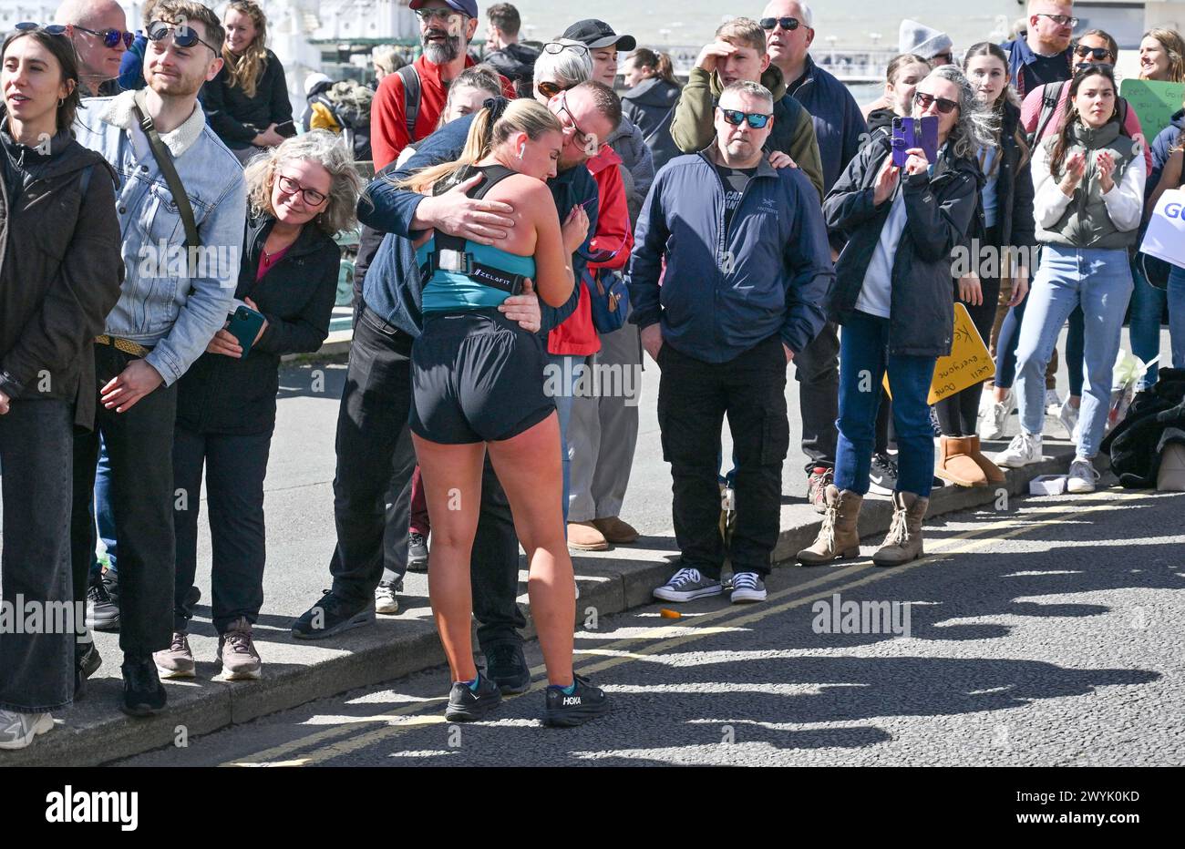 Brighton UK 7. April 2024 - dieser Läufer hält für eine Umarmung an, während Tausende an einem sonnigen, aber windigen Tag am Brighton Marathon teilnehmen: Credit Simon Dack / Alamy Live News Stockfoto