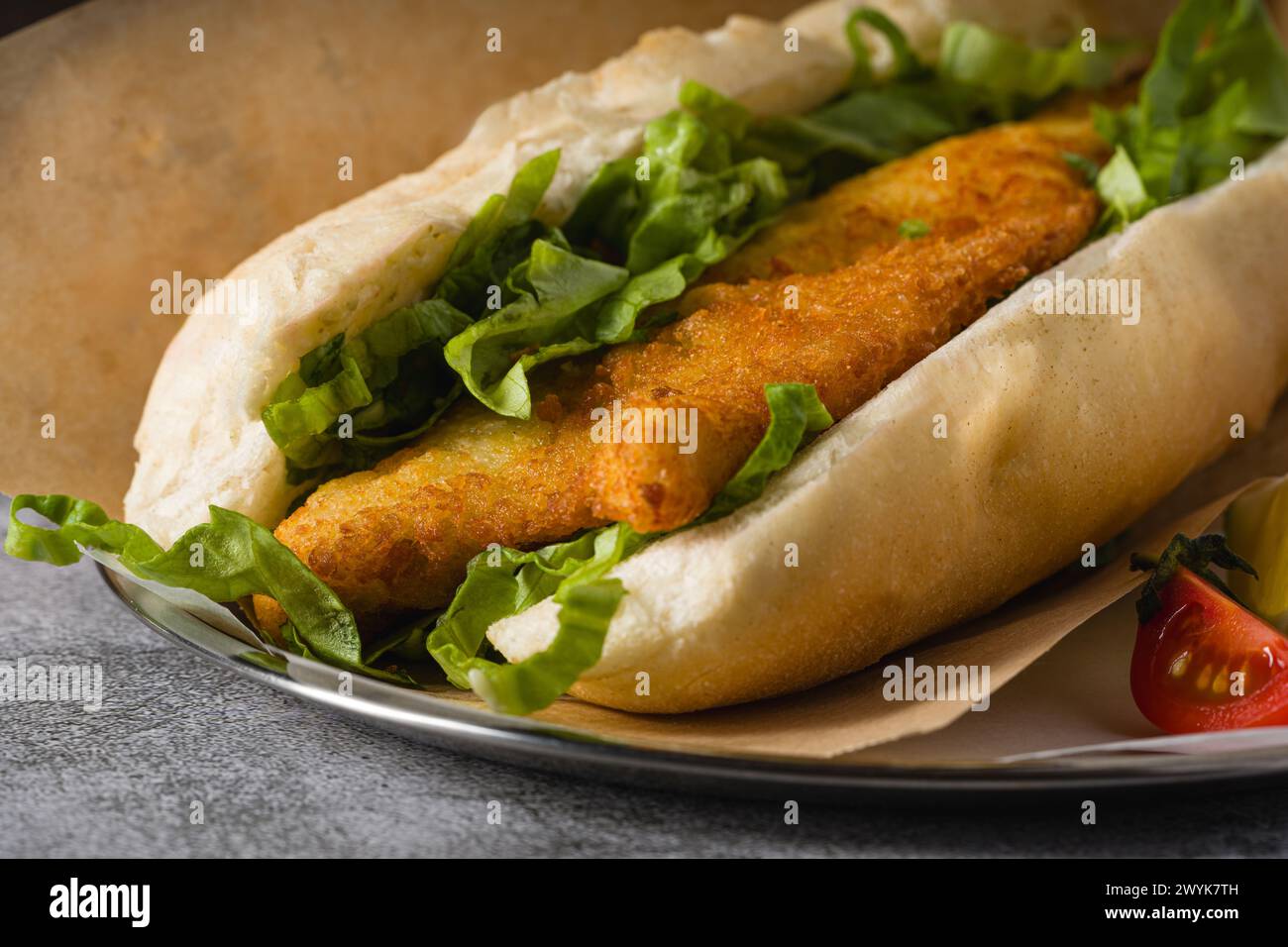 Gebratenes Fisch-Sandwich mit Gemüse auf dem Steintisch. Türkischer Name Balik Ekmek Stockfoto