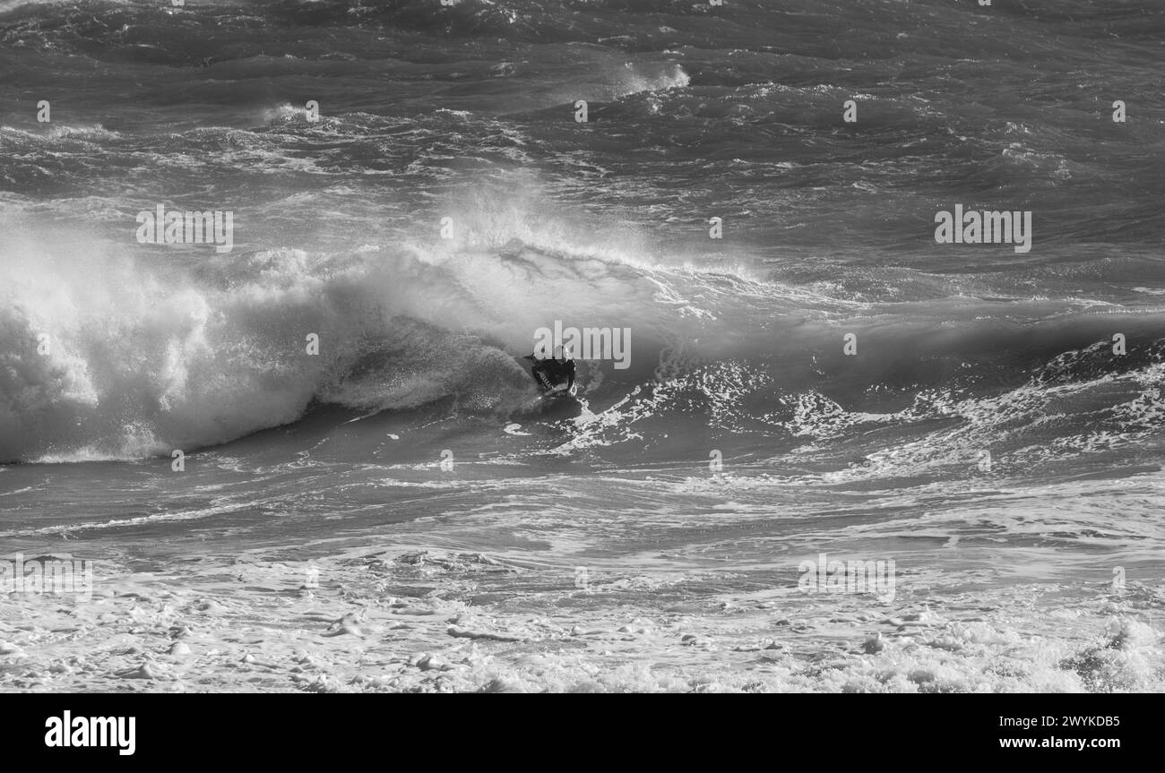 Wellenbretter oder Body Board Surfen in riesigen Breaks in Kynance Cove, Cornwall. Den Wellen trotzen. Stockfoto