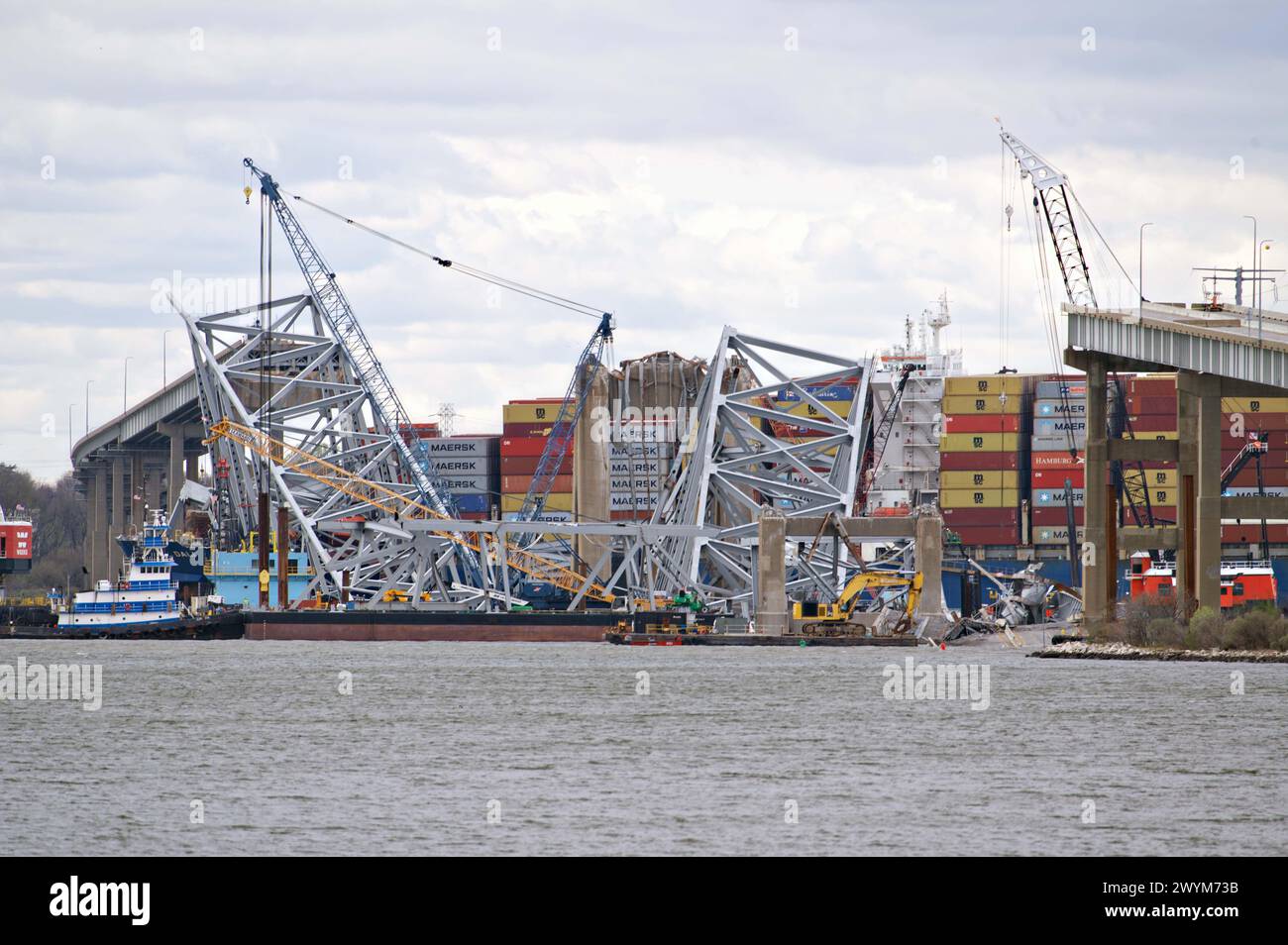 Dundalk, Vereinigte Staaten von Amerika. April 2024. Ein Gewirr von Metallträgern und Kränen umgibt die zusammengestürzte Francis Scott Key Bridge während des Besuchs des US-Präsidenten Joe Biden vom Sollers Point aus gesehen am 5. April 2024 in Dundalk, Maryland. Am 26. März brach das 984-Fuß-Containerschiff Dali auf die Brücke ein und tötete sechs Arbeiter. Quelle: Joe Andrucyk/MDGovpics/Alamy Live News Stockfoto