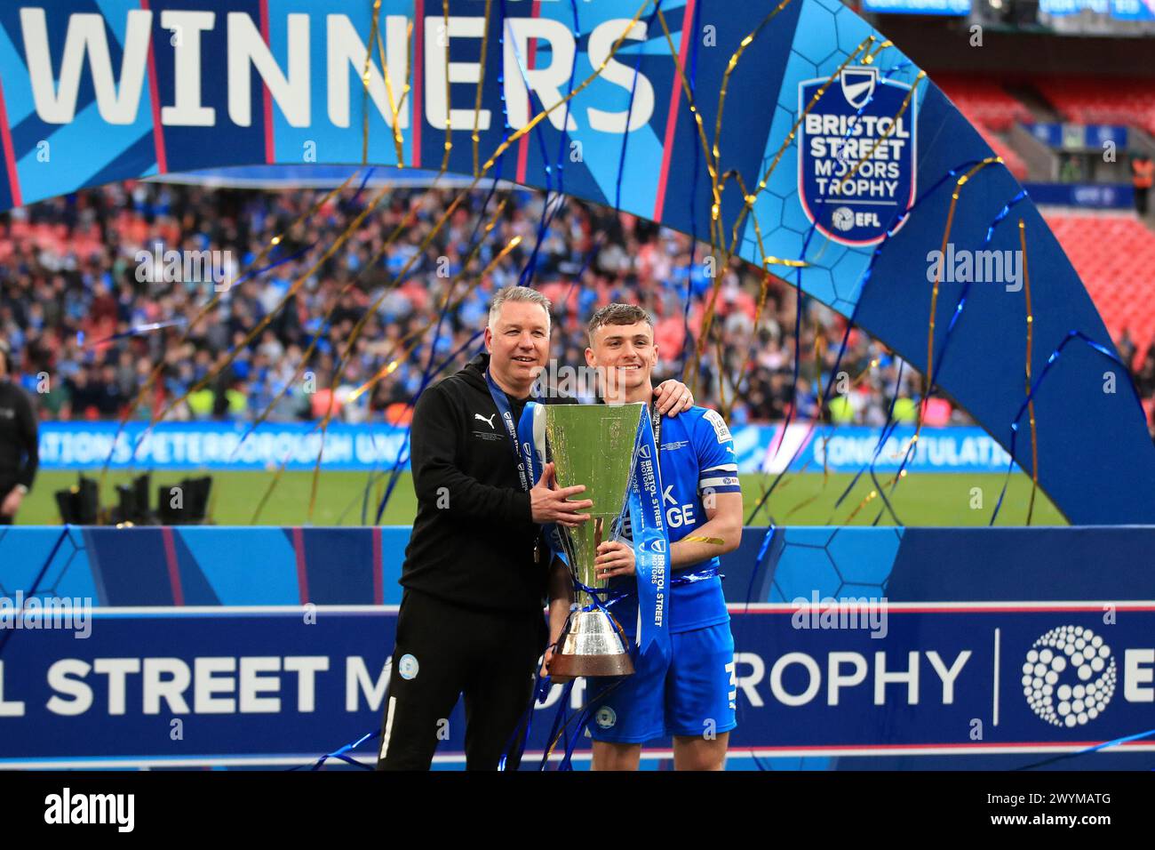 London, Großbritannien. April 2024. Harrison Burrows von Peterborough United und Darren Ferguson, Manager von Peterborough United, posierten mit der Trophäe während des EFL Trophy Final zwischen Peterborough United und Wycombe Wanderers am 7. April 2024 im Wembley Stadium in London. Foto von Carlton Myrie. Nur redaktionelle Verwendung, Lizenz für kommerzielle Nutzung erforderlich. Keine Verwendung bei Wetten, Spielen oder Publikationen eines einzelnen Clubs/einer Liga/eines Spielers. Quelle: UK Sports Pics Ltd/Alamy Live News Stockfoto