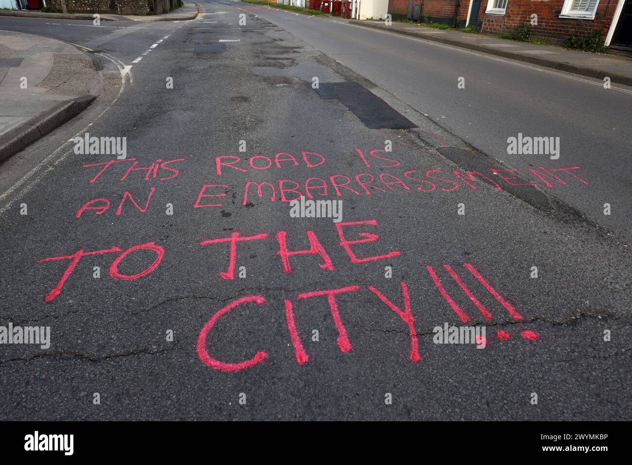 Graffiti auf den Straßen von Chichester, West Sussex, Großbritannien, beschweren sich nach Jahren der Vernachlässigung über die Topflöcher und den Zustand der Straßen. Stockfoto