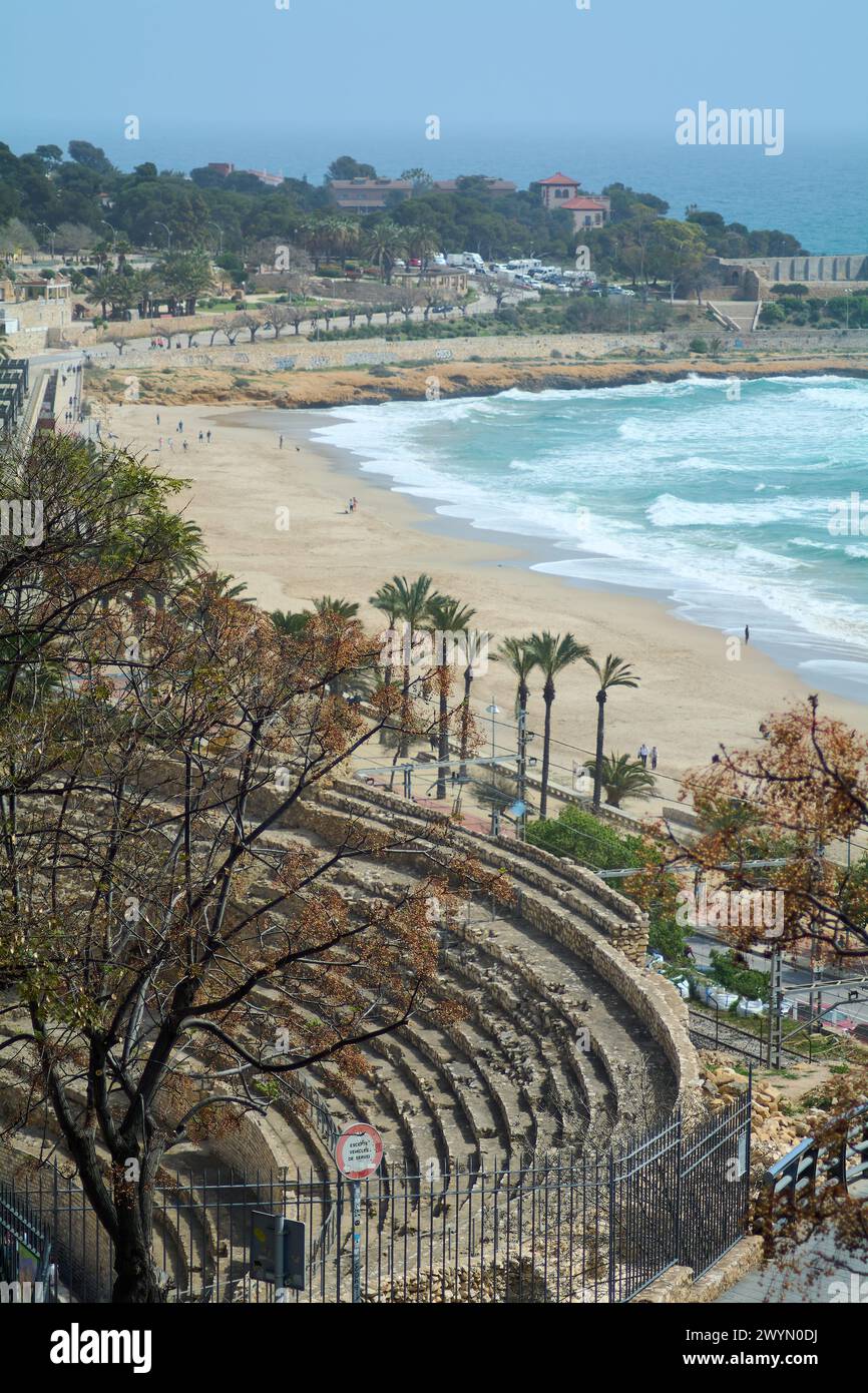 Das römische Amphitheater von Tarragona mit seiner Steinstruktur, mit Blick auf den goldenen Strand und das blaue Meer, erinnert an Geschichte und natürliche Schönheit. Stockfoto