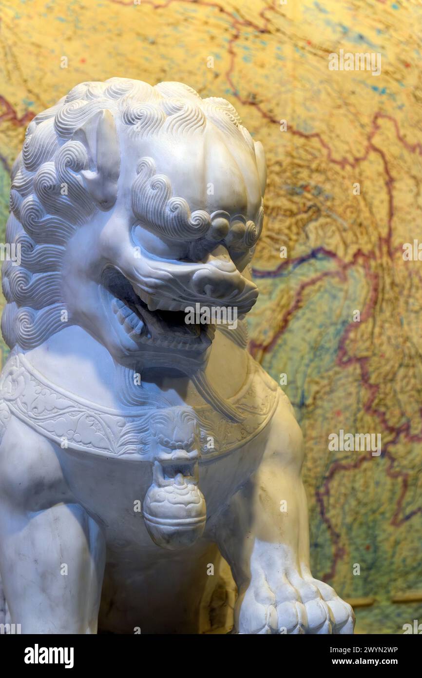 Chinesischer Steinlöwe vor einer alten Karte von China Stockfoto