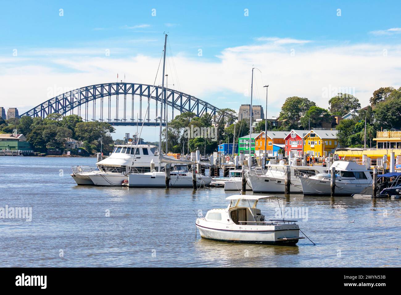 Mort Bay auf der Halbinsel Balmain mit Blick auf die Hafenbrücke von Sydney und die in ihren hellen Farben gemalten Werkstätten des Waterview Wharfs, Sydney, Australien Stockfoto