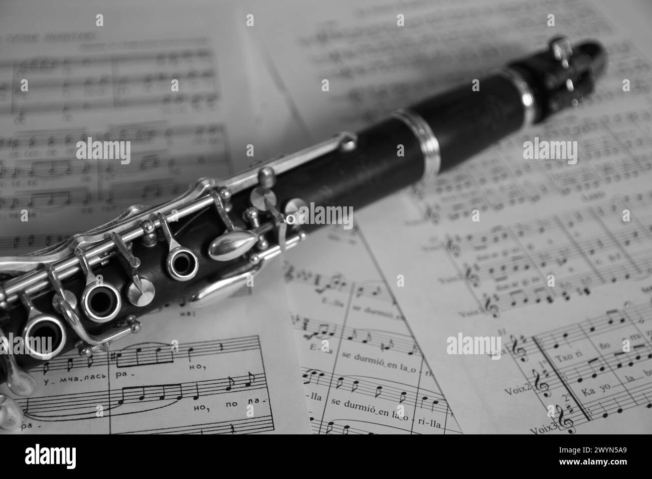 Nahaufnahme einer Klarinette, ein typisches Blasinstrument, das in Bands verwendet wird, auf einigen Notenblättern. Schwarzweißbild Stockfoto