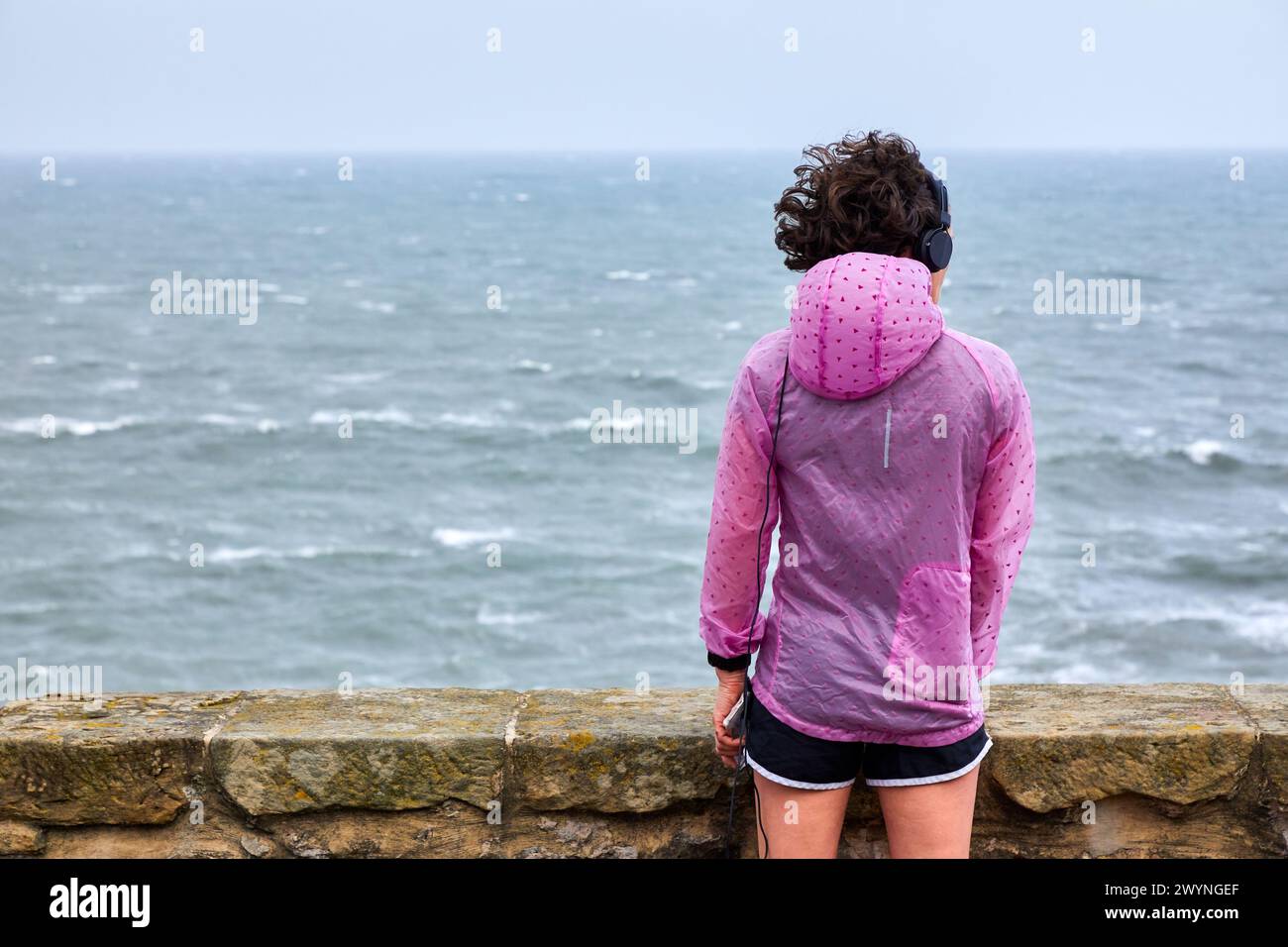 Frau, die Sport macht und auf das Meer blickt, Paseo Nuevo, Donostia, San Sebastian, Gipuzkoa, Baskenland, Spanien. Stockfoto